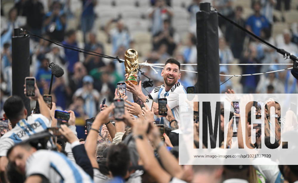 Football, men, season 2022 23, World Cup in Qatar, final, Argentina France 2 2, 3 3 n V, 4 2 i E at Lusail Iconic Stadium in Lusail, Lionel Messi Argentina with trophy, he is carried on shoulders long after the end of the game in the area behind the goal, he is photographed and filmed by fans with cell phones, cheering after the final whistle, 18 12 2022,