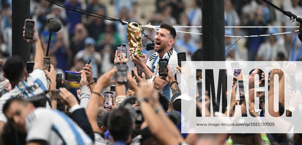 Football, men, season 2022 23, World Cup in Qatar, final, Argentina France 2 2, 3 3 n V, 4 2 i E at Lusail Iconic Stadium in Lusail, Lionel Messi Argentina with trophy, he is carried on shoulders long after the end of the game in the area behind the goal, he is photographed and filmed by fans with cell phones, cheering after the final whistle, 18 12 2022,