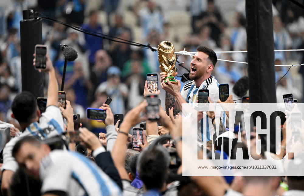 Football, men, season 2022 23, World Cup in Qatar, final, Argentina France 2 2, 3 3 n V, 4 2 i E at Lusail Iconic Stadium in Lusail, Lionel Messi Argentina with trophy, he is carried on shoulders long after the end of the game in the area behind the goal, he is photographed and filmed by fans with cell phones, cheering after the final whistle, 18 12 2022,