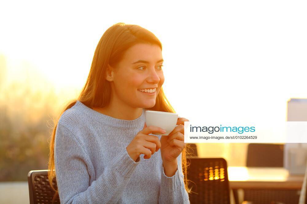 IMAGO Creative, Frühling, Start der Straßencafe-Saison Happy girl relaxing drinking coffee at sunset in a cafe