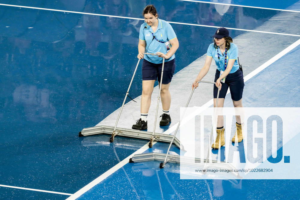 MELBOURNE, VIC - JANUARY 24: Ballkids and other tennis officials mop up after rain interrupted play during the Quarterfinals of the 2023 Australian Open on January 24 2023, at Melbourne Park in Melbourne, Australia. (Photo by Jason Heidrich Icon Sportswire) TENNIS: JAN 24 Australian Open Icon230124007