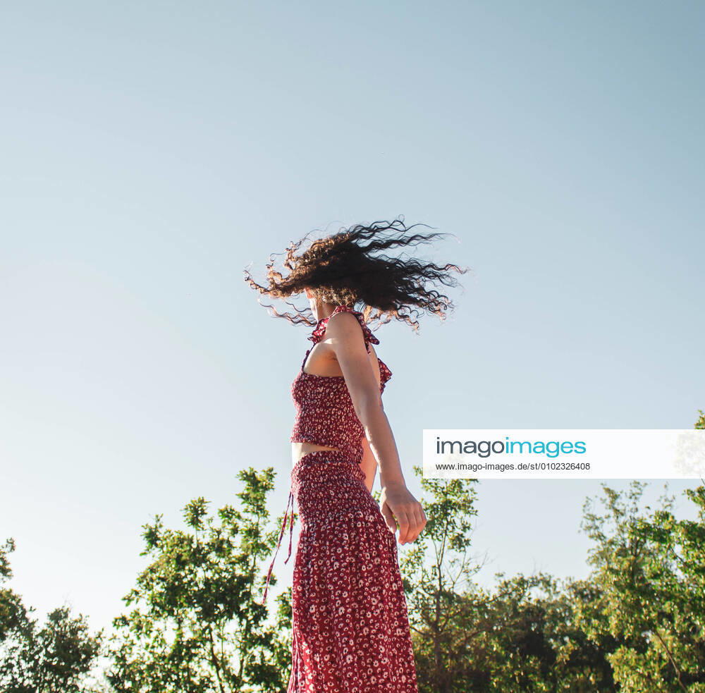 Brunette girl moving hair with long summer dress against blue sky Burgos, CL, Spain CR_NELA200703D-442155-01 ,model released, Symbolfoto