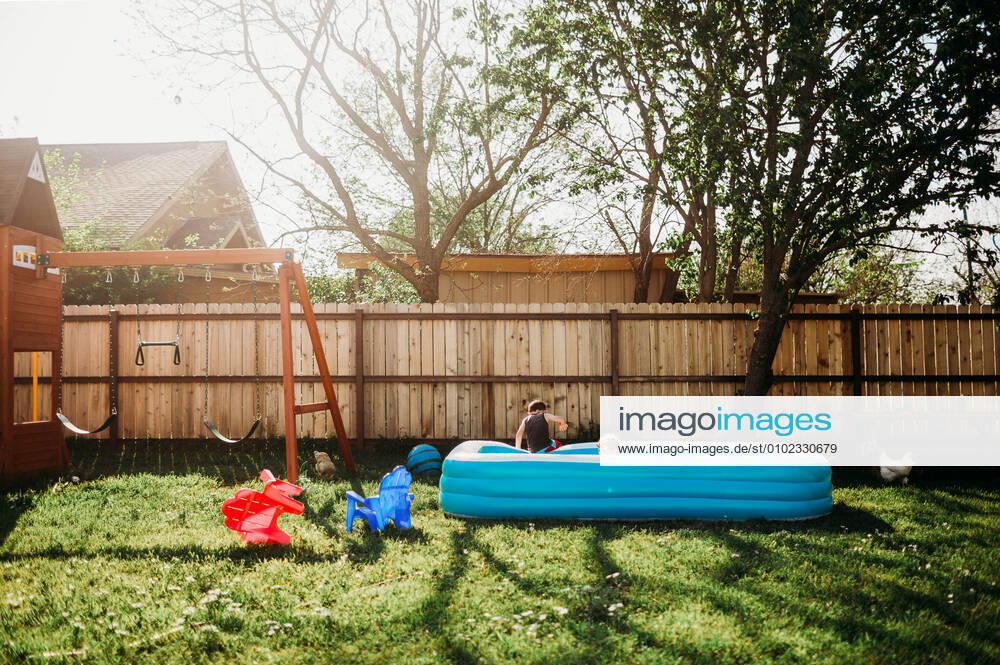 Two young kids swimming in backyard pool by swing set Fort Worth, TX, United States CR_TAHI200701-413968-01 ,model released, Symbolfoto