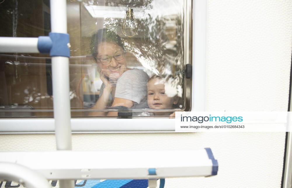 Mother and child looking out of a residential trailer Bonn Germany