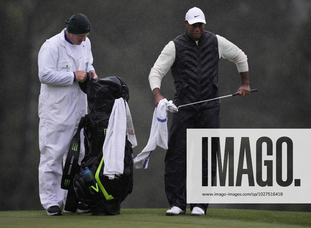 Tiger Woods dries his putter alongside caddie Joe LaCava at the 18th hole during the rain-delayed second round at the 87th Masters tournament at Augusta National Golf Club in Augusta, Georgia on Saturday, April 8, 2023. Woods finished at 147, 3 shots over par, but made the cut for the 23rd consecutive time tying Gary Player and Fred Couples. AUG20230408214 BOBxSTRONG