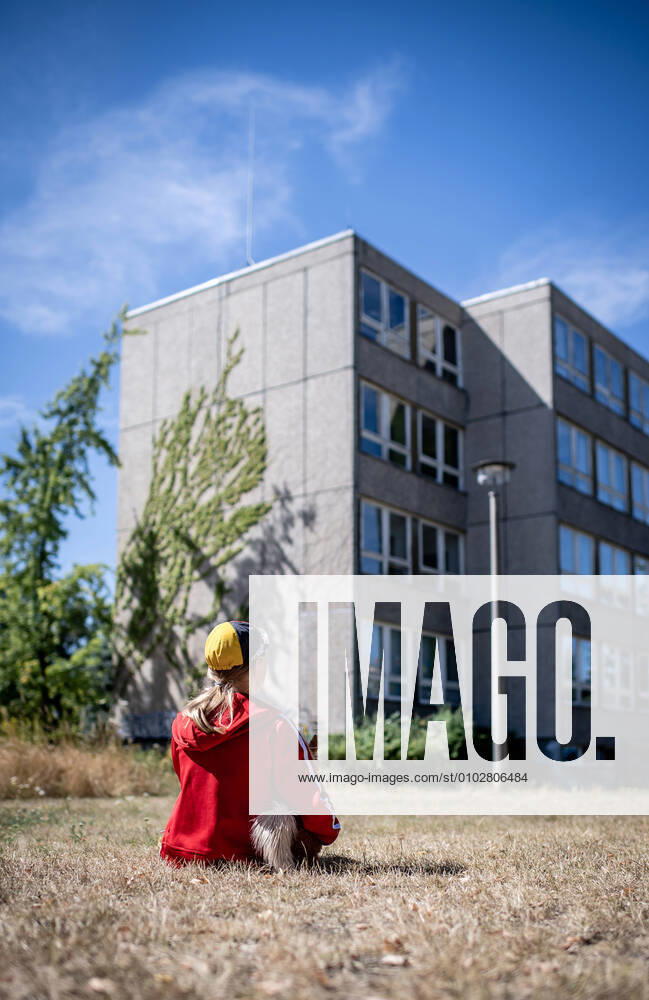 Leipzig Saxony , Gruenau district A child sits in front of a prefabricated concrete building in Leipzig Gruenau