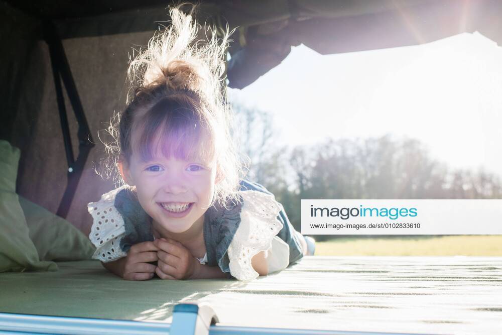 Portrait of a young girl sat in a roof top tent smiling at sunset Norrtälje, Stockholm County, Sweden CR_RABE200627-418710-01 ,model released, Symbolfoto