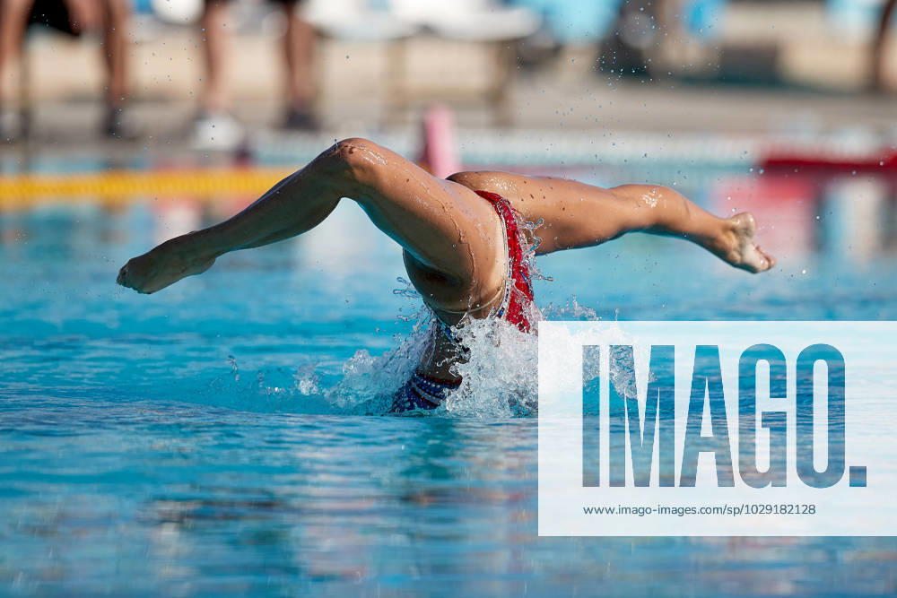 TAL-QROQQ, MALTA, 29 APRIL 2023: The legs of Malta national team, Nationalteam artistic swimmer Ana Culic (mostly submerged), point sideways out of the water as she performs a Barracuda Airborne Split, Spin Up 180 degrees during her artistic swimming performance at the National Pool, Tal-Qroqq, Malta on 29 April 2023. Ana Culic - Malta Artistic Swimmer AQUA_MAS_2023