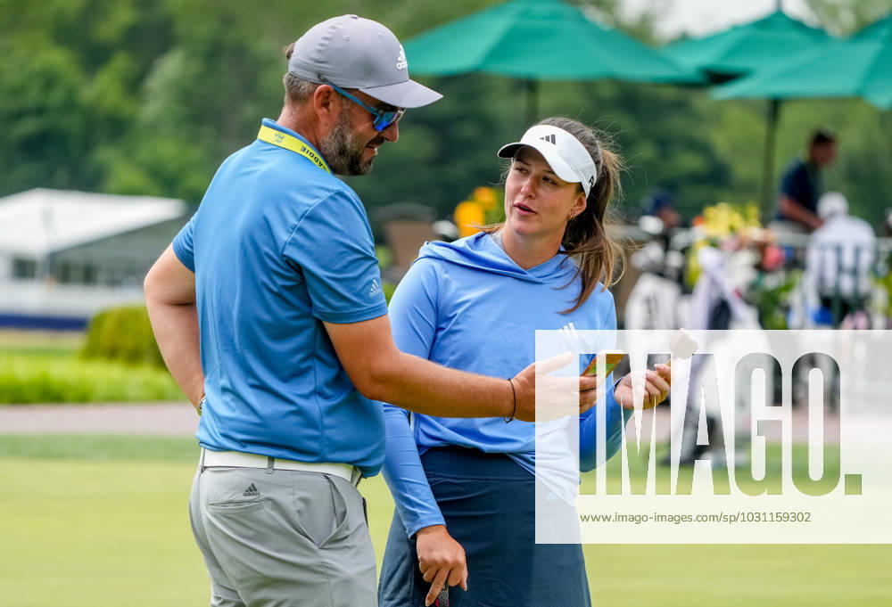Linn Grant (SWE) eats an ice cream bar as she talks with her coach as she practices her putting at the KPMG Womens Golf Championship at Baltusrol Golf Club in Springfield, NJ on June 21, 2023. Eclipse Sportswire CSM Springfield USA - ZUMAcs17 20230621_zaf_cs17_005