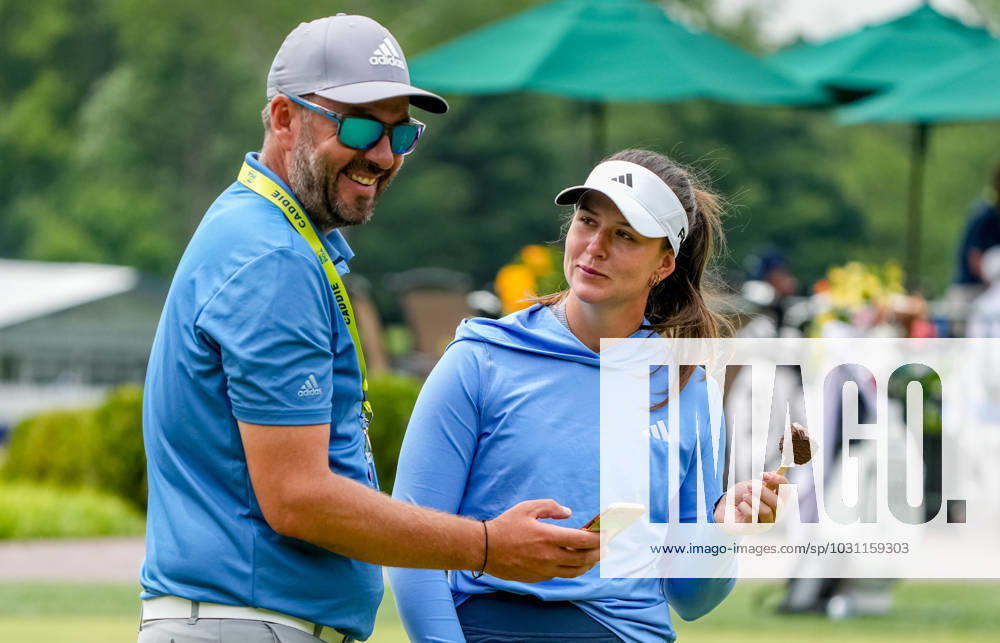 Linn Grant (SWE) eats an ice cream bar as she talks with her coach as she practices her putting at the KPMG Womens Golf Championship at Baltusrol Golf Club in Springfield, NJ on June 21, 2023. Eclipse Sportswire CSM Springfield USA - ZUMAcs17 20230621_zaf_cs17_006