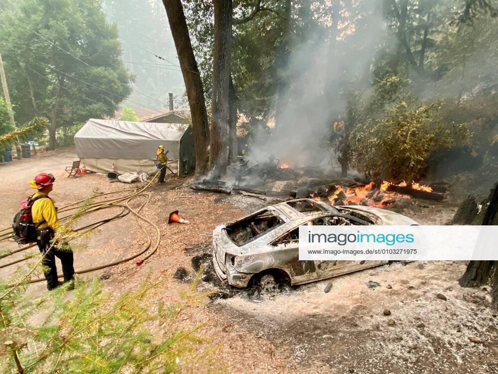 CZU Lightning Complex Fire: Boulder Creek Area, near Santa Cruz. An all-volunteer crew that makes up the Boulder Creek Fire Department worked around the clock to save houses, such as this property and the one next to it, where a huge and now dangerous pile of wood sits. The car burned yesterday but embed re-ignited it. Boulder Creek USA - ZUMAk144 20200822_znp_k144_047
