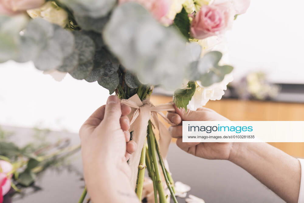 Hands of male florist preparing bouquet model released Symbolfoto DSIF00082