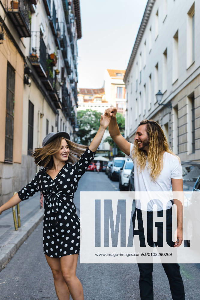 Stylish couple dancing on street amidst buildings in city model released Symbolfoto JMPF00279