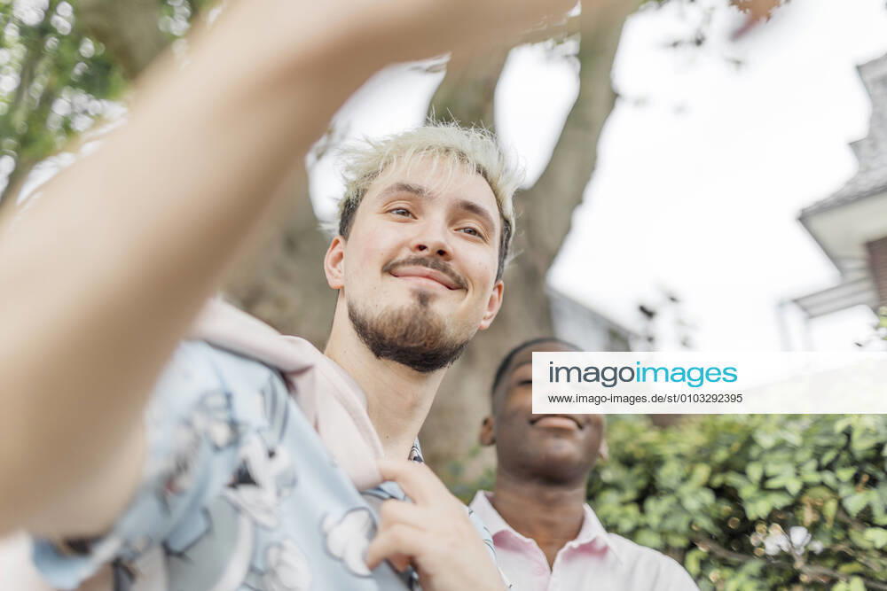 Smiling men looking away in city model released Symbolfoto KMKF01443