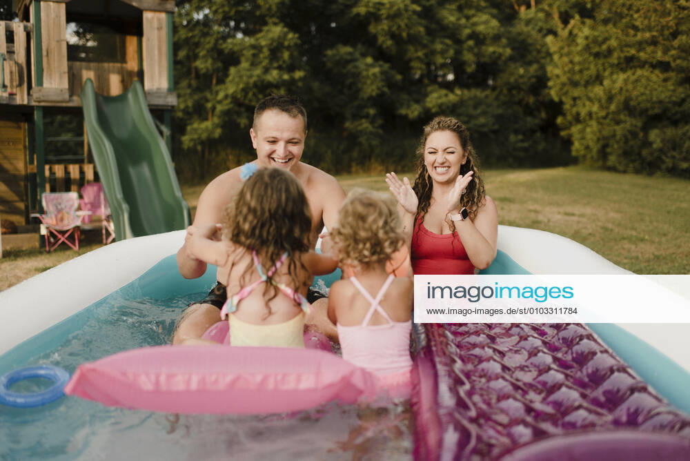 Happy family in an inflatable swimming pool in garden model released Symbolfoto property released SMSF00118