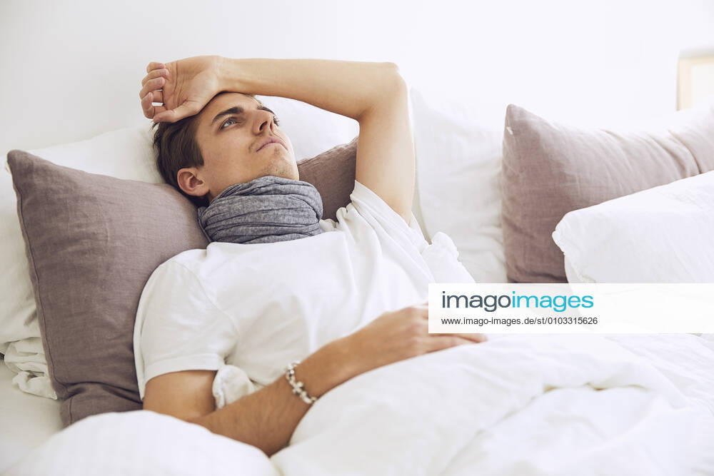 Sick thoughtful young man resting on bed at home model released Symbolfoto property released UKOF00016