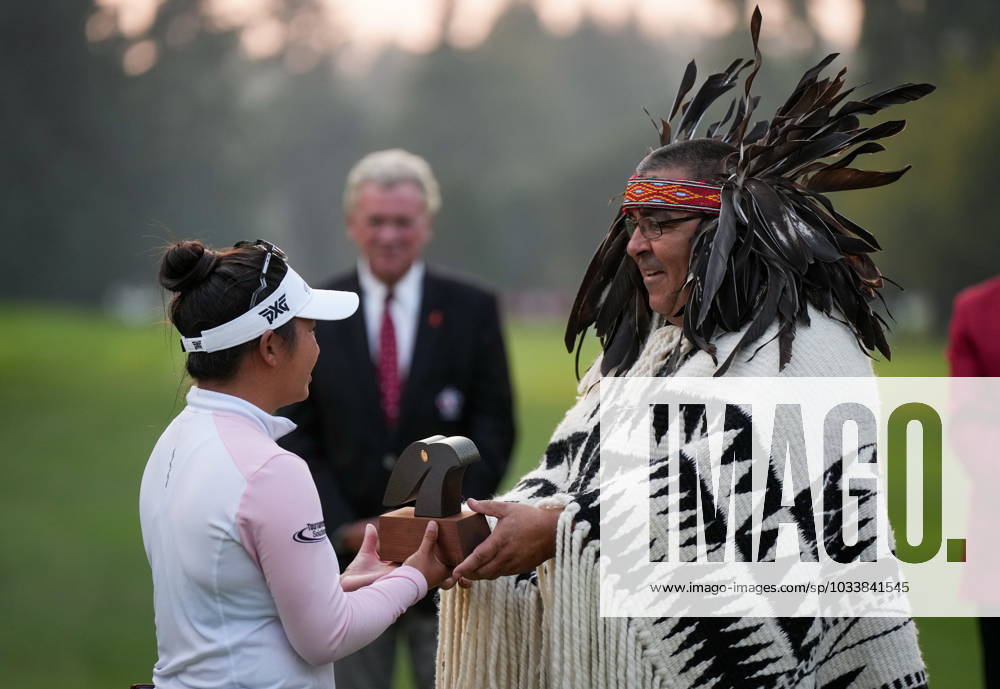 Megan Khang, left, of the U.S., receives a carving from Musqueam Indian band Chief Wayne Sparrow after winning the LPGA, Golf Damen CPKC Canadian Women s Open golf tournament on the first playoff hole, in Vancouver, on Sunday, August 27, 2023. Canada News - August 27, 2023 - ZUMAc35_ 20230827_zaf_c35_172