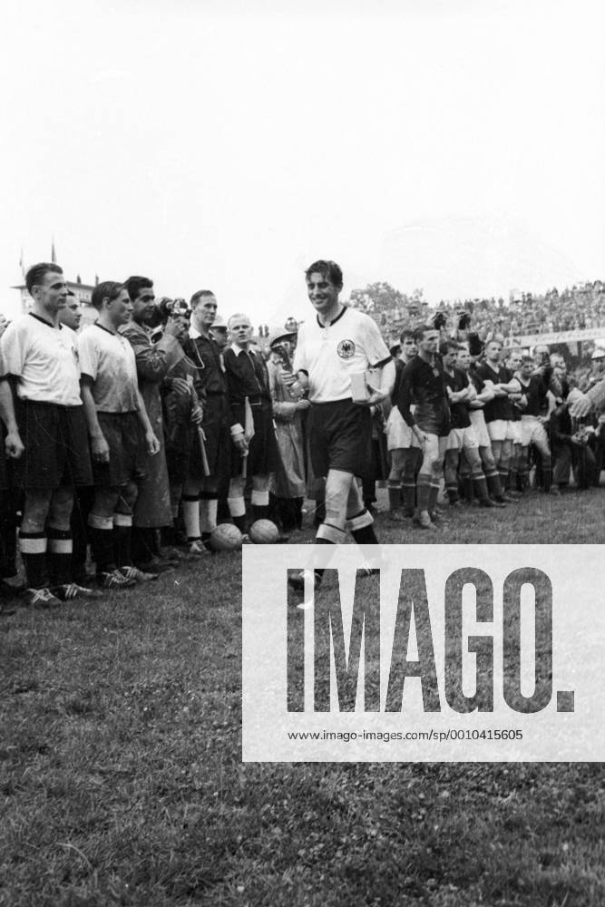 WM Finale 1954 in Bern - BR Deutschland - Ungarn 3:2 - Weltmeister Fritz Walter mit dem Coupe Jules Rimet, daneben u.a. seine Teamkollegen Karl Mai (li.) und Max Morlock (3.v.li., alle BRD) sowie Schiedsrichter William Ling (England) und dessen Linienrichter Benjamin Griffith (Wales) und Vincenzo Orlandini (Italien), re. das enttäuschte Nationalteam Ungarns