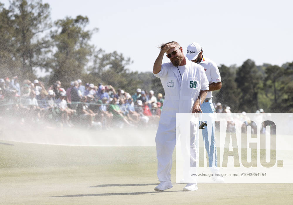 Max Homa and caddie Joe Greiner withstand the gusting wind that blows sand from the bunker across the eighteenth green during the second round of the Masters Tournament at Augusta National Golf Club in Augusta, Georgia on Friday, April 12, 2024. Woods finished the day at one-over-par. AUG202404121008 JOHNxANGELILLO