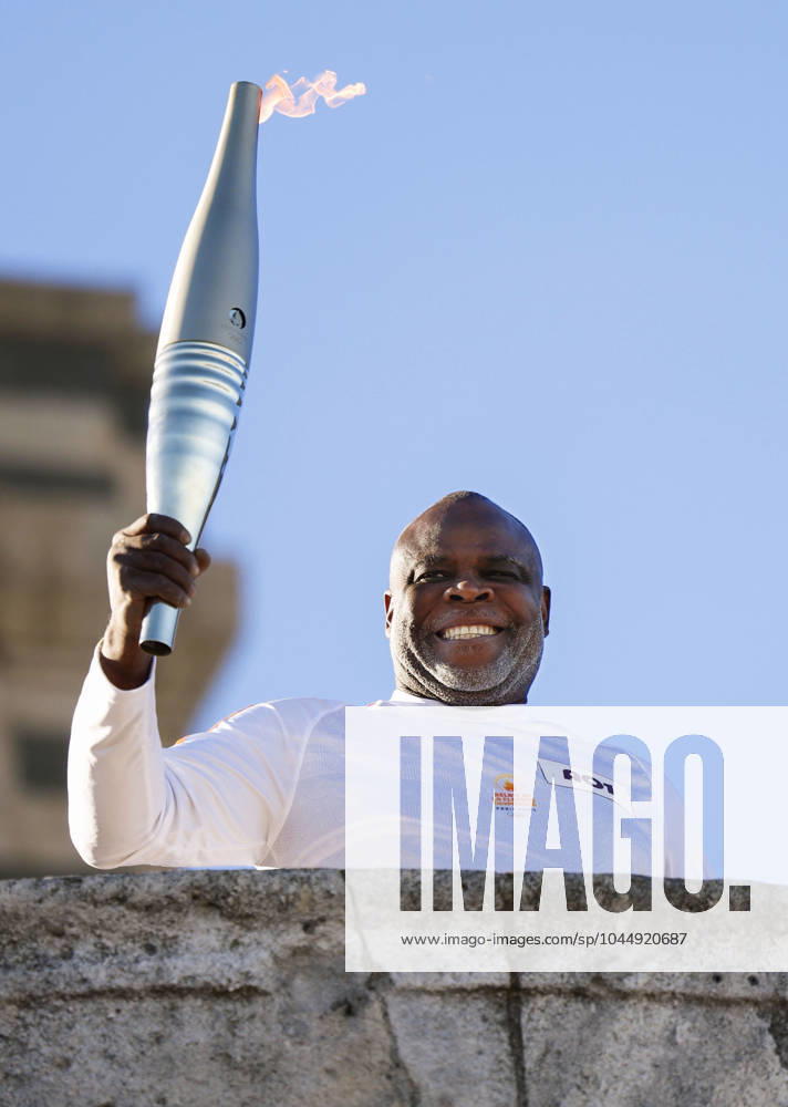 Paris Olympic torch relay begins Former French football player Basile Boli raises the Olympic torch in Marseille on May 9, 2024, as the Paris Olympic torch relay begins following the arrival of the Olympic flame in the southern French port city on a majestic three-mast ship. About 10,000 torchbearers are to pass through over 400 towns until the games opening ceremony in Paris on July 26. A14AA0002809050P