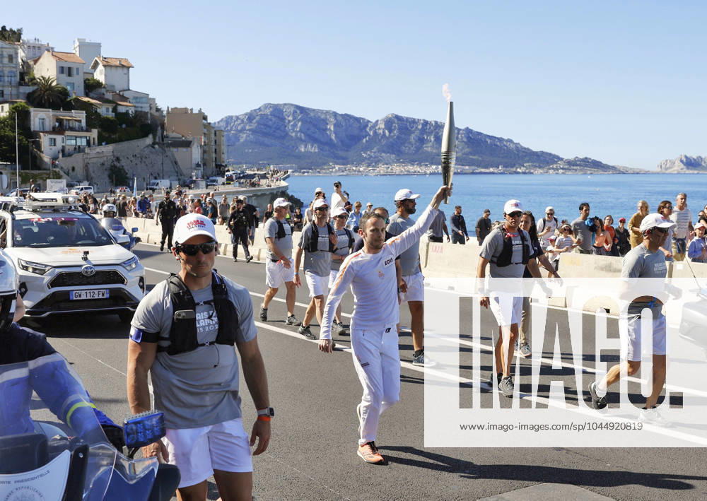 Paris Olympic torch relay begins A torchbearer runs in Marseille on May 9, 2024, as the Paris Olympic torch relay begins following the arrival of the Olympic flame in the southern French port city on a majestic three-mast ship. About 10,000 torchbearers are to pass through over 400 towns until the games opening ceremony in Paris on July 26. A14AA0002809053P