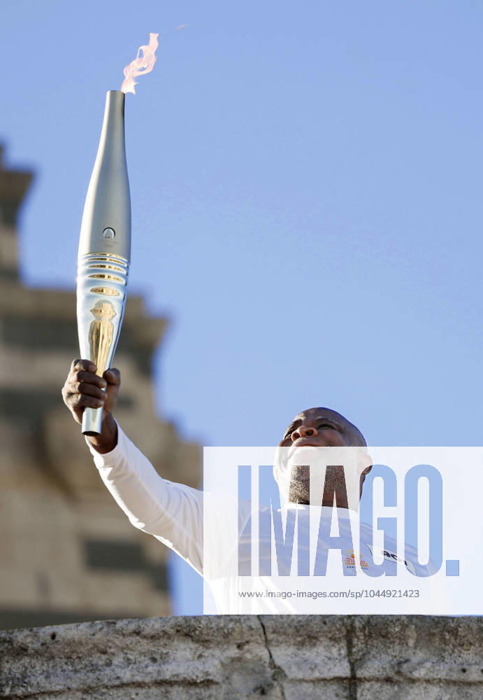 Paris Olympic torch relay begins Former French football player Basile Boli raises the Olympic torch in Marseille on May 9, 2024, as the Paris Olympic torch relay begins following the arrival of the Olympic flame in the southern French port city on a majestic three-mast ship. About 10,000 torchbearers are to pass through over 400 towns until the games opening ceremony in Paris on July 26. A14AA0002809179P