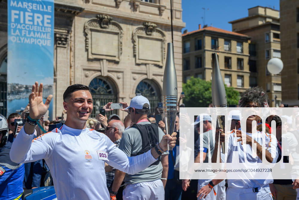 (240509) -- MARSEILLE, May 9, 2024 -- Dancer Maryam Kaba (R) passes the Olympic Torch to local firefighter Matthieu Gudet during the relay of the Olympic flame of Paris 2024 in Marseille, France, May 9, 2024. (Photo by Xinhua) (SP)FRANCE-MARSEILLE-2024 PARIS OLYMPIC-TOURCH RELAY JulienxMattia