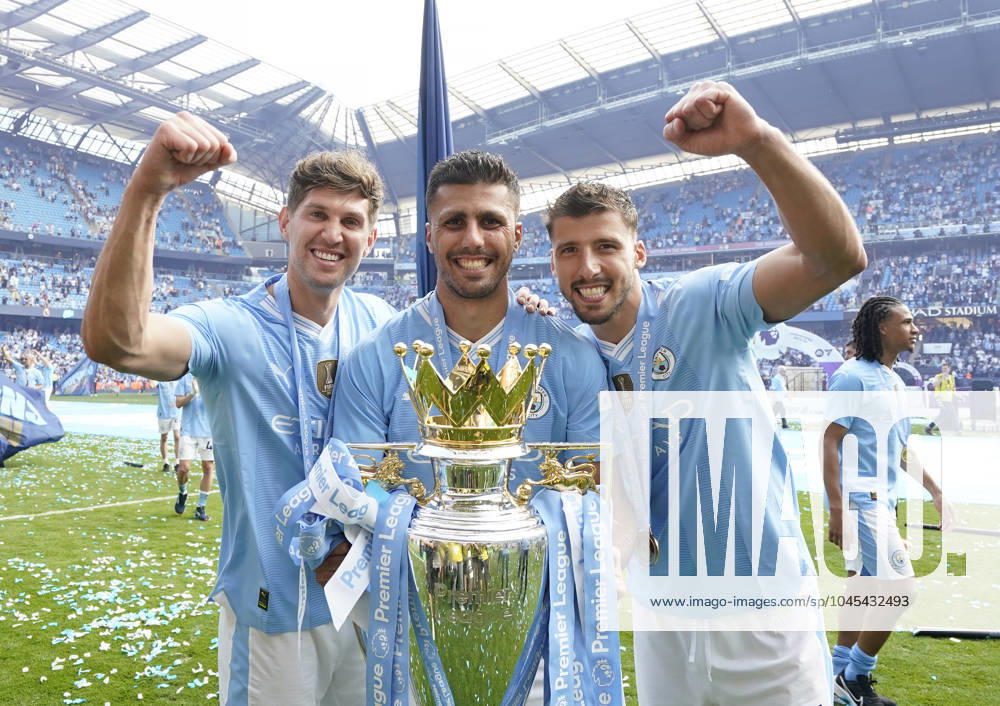 Manchester, England, 19th May 2024. Rodri of Manchester City (C), John Stones of Manchester City (L) and Ruben Dias of Manchester City celebrate with the Premier league trophy during the Premier League match at the Etihad Stadium, Manchester. Picture credit should read: Andrew Yates Sportimage . SPI-3159-0020
