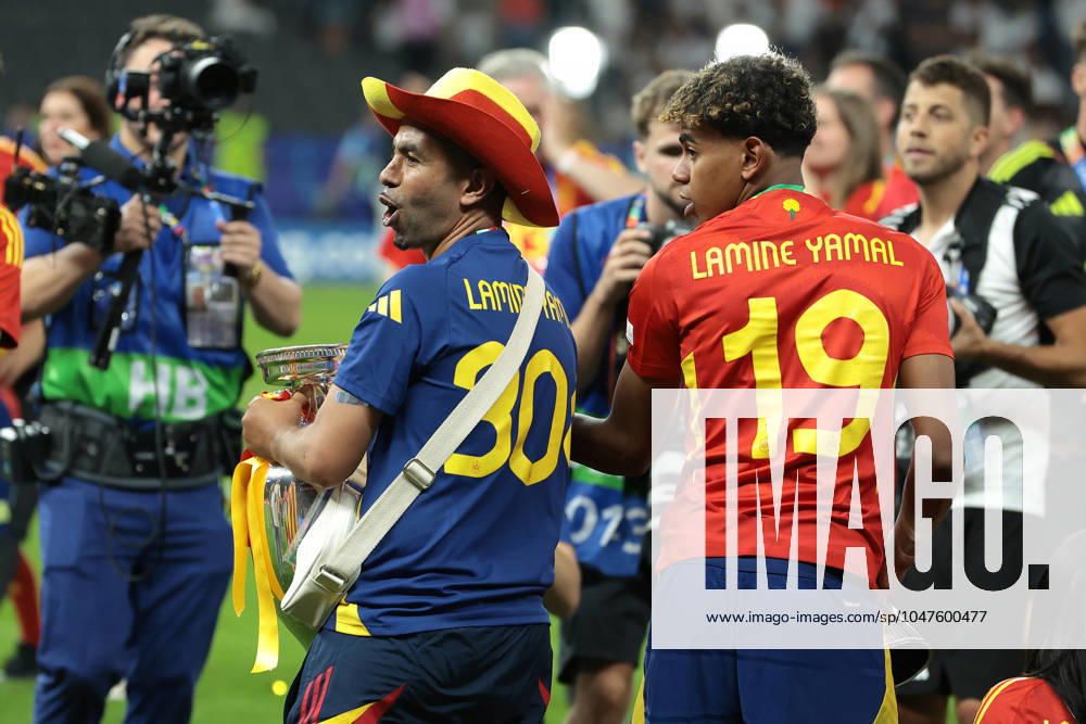 Berlin, Germany, 14th July 2024. Lamine Yamal of Spain looks on as his Father Mounir Nasraoui celebrates with the Henri Delaunay Cup following the 2-1 victory in the UEFA European Championships final match at Olympiastadion, Berlin. Picture: Jonathan Moscrop Sportimage . SPI-3226-0187