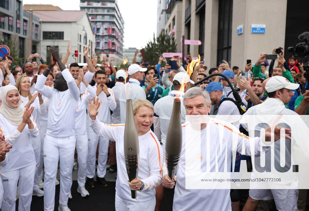 (240726) -- PARIS, July 26, 2024 -- International Olympic Committee (IOC) President Thomas Bach (R) and Chair of the IOC Athletes Commission Emma Terho take part in the Olympic Village torch relay in the Olympic Village in Paris, France, July 26, 2024. (Photo by POOL Xinhua) (PARIS2024)FRANCE-PARIS Olympic Games, Olympische Spiele, Olympia, OS TORCH RELAY JiaxHaocheng