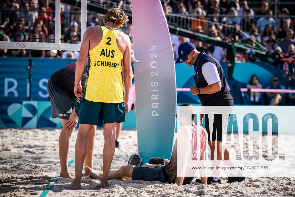Paris, Eiffel Tower Stadium Beach volleyball, Olympic Games, preliminary round Clemens Wickler GER trips over net camera and injures himself Zachery Schubert AUS , Nils Ehlers GER and referee Giovanni Bake RSA with him