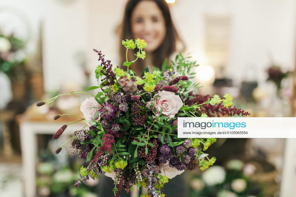 Woman holding bunch of flowers while standing at flower shop model released Symbolfoto property released MRRF00402