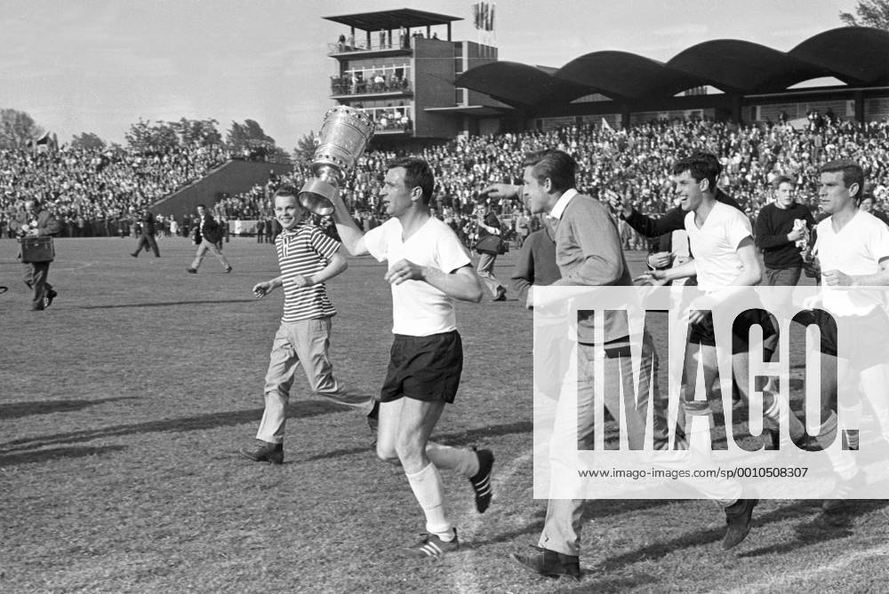 Kapitän Alfred Aki Schmidt (Borussia Dortmund) präsentiert den DFB Pokal, daneben Fans sowie Hermann Straschitz (re.) und Lothar Emmerich