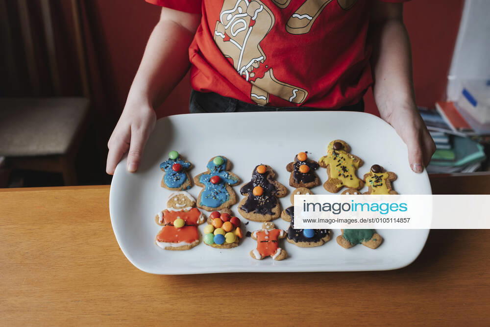 Front view of a girl showing her decorated gingerbread on a plate Hawera, Taranaki, New Zealand CR_LVBS200923-487941-01 ,model released, Symbolfoto