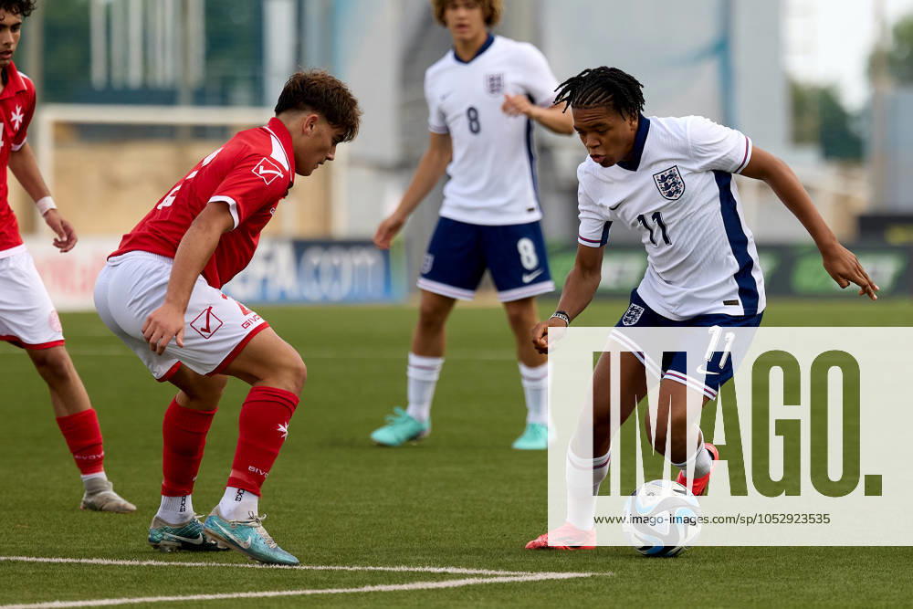 Rio Ngumoha (R) of England takes on Drew Miceli of Malta during the playing of their countrys national anthem prior to the UEFA European Under-17 Championship 2025 Group 1 qualifying soccer match between England and Malta at the Centenary Stadium, Ta Qali, Malta on October 24, 2024. England v Malta - Under-17 Championship UEFA Qualifying 2025 UEFA_U17_QLFY_25