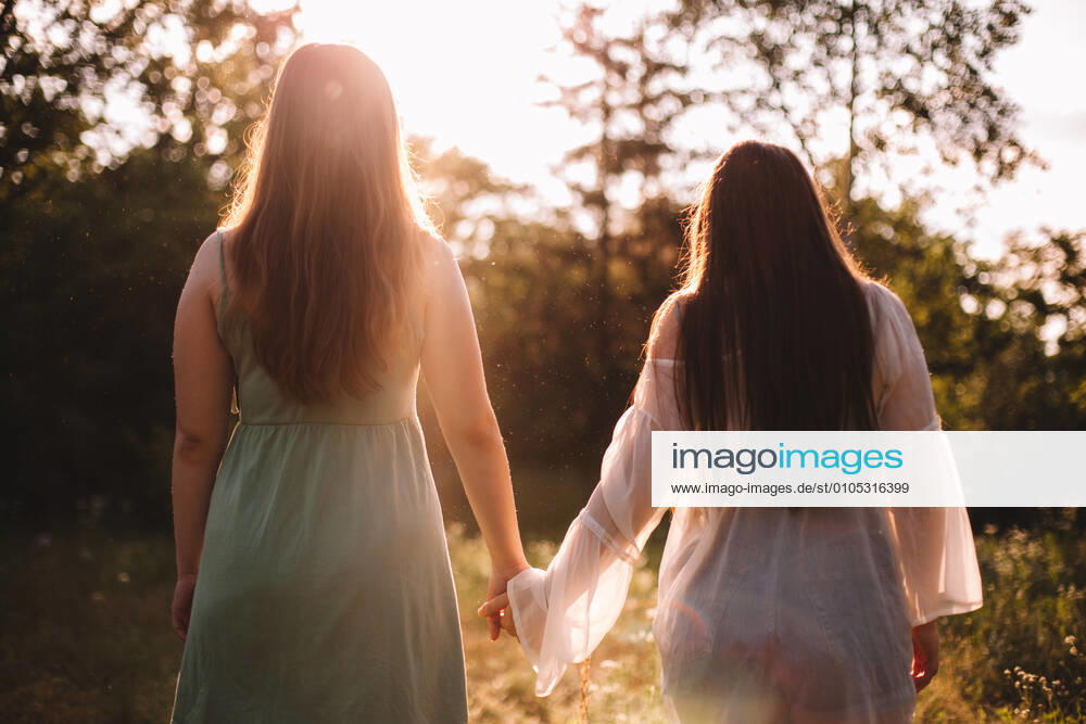 Back view of lesbian couple holding hands while standing in forest CR_DMBE200923-468581-01 ,model released, Symbolfoto