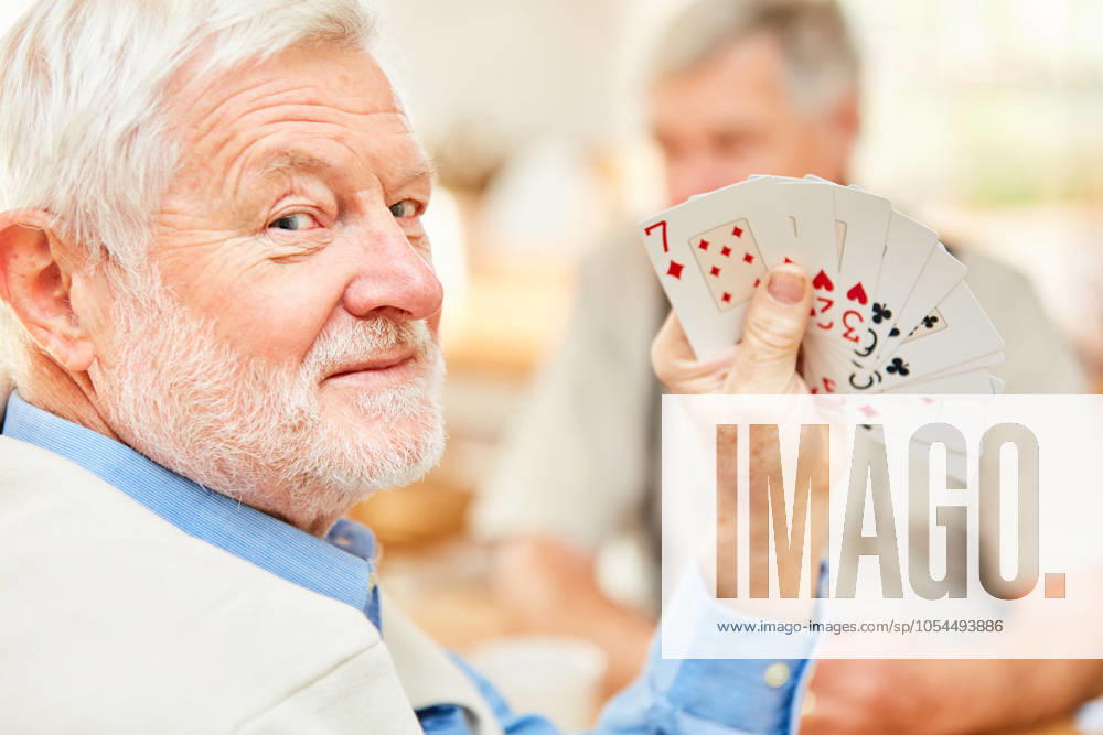 Senior zeigt seine Karten und hat Spaß mit seiner Strategie beim Turnier Kartenspiel (License=RM) 12592355 ,model released, Symbolfoto ,property released