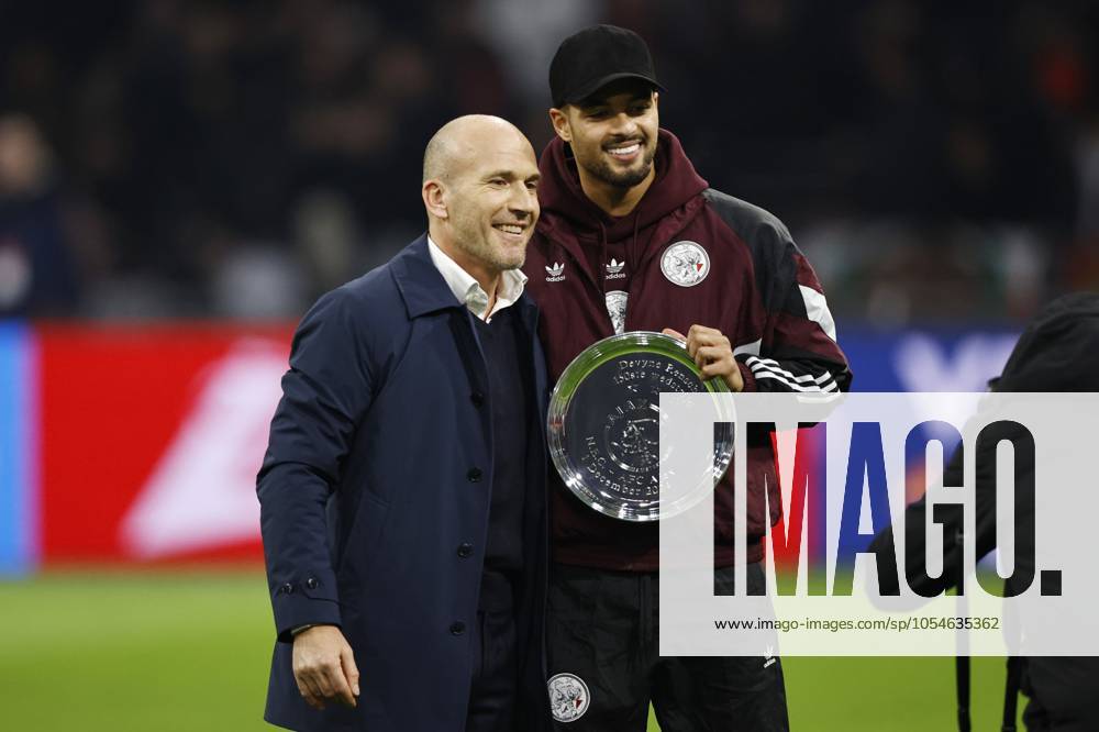 AMSTERDAM - (l-r) Ajax technical director Alex Kroes, Devyne Rensch of Ajax receives a bowl for 150 games in Ajax 1 during the Dutch Eredivisie match between Ajax Amsterdam and FC Utrecht at the Johan Cruijff ArenA on Dec. 4, 2024 in Amsterdam, Netherlands. ANP MAURICE VAN STEEN Dutch Eredivisie 2024 25 ANPxSportx IVx 514904421 originalFilename: 514904421