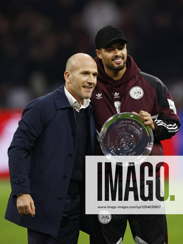 AMSTERDAM - (l-r) Ajax technical director Alex Kroes, Devyne Rensch of Ajax receives a bowl for 150 games in Ajax 1 during the Dutch Eredivisie match between Ajax Amsterdam and FC Utrecht at the Johan Cruijff ArenA on Dec. 4, 2024 in Amsterdam, Netherlands. ANP MAURICE VAN STEEN Dutch Eredivisie 2024 25 ANPxSportx IVx 514904955 originalFilename: 514904955