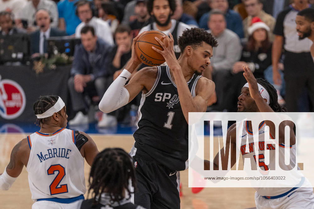 KW52 Victor Wembanyama (C) of San Antonio Spurs defends a ball against Precious Achiuwa of Knicks during an NBA, Basketball Herren, USA game between the New York Knicks and San Antonio Spurs at Madison Square Garden in New York, United States, 25 December 2024. NBA: New York Knicks vs San Antonio Spurs !ACHTUNG: NUR REDAKTIONELLE NUTZUNG!