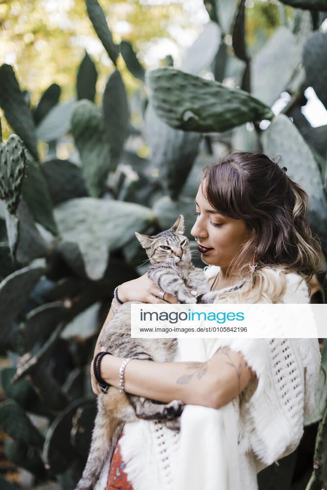 Woman holding cat while standing against plant model released Symbolfoto property released DCRF00917