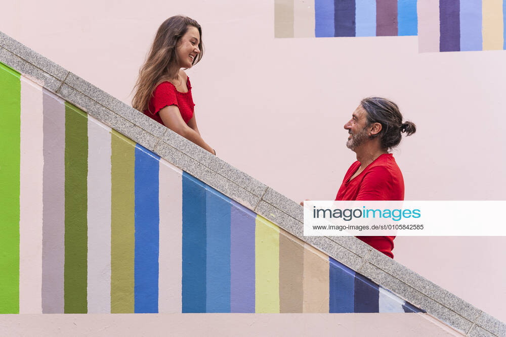 Father and daughter standing on colorful staircase during sunny day model released Symbolfoto DLTSF01126