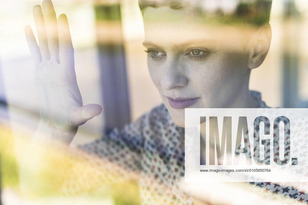 IMAGO Creative: Corporate: Klimaschutz, Digitalisierung und Urbanisierung Close-up of thoughtful female professional looking through window in office model released Symbolfoto property released UUF21523