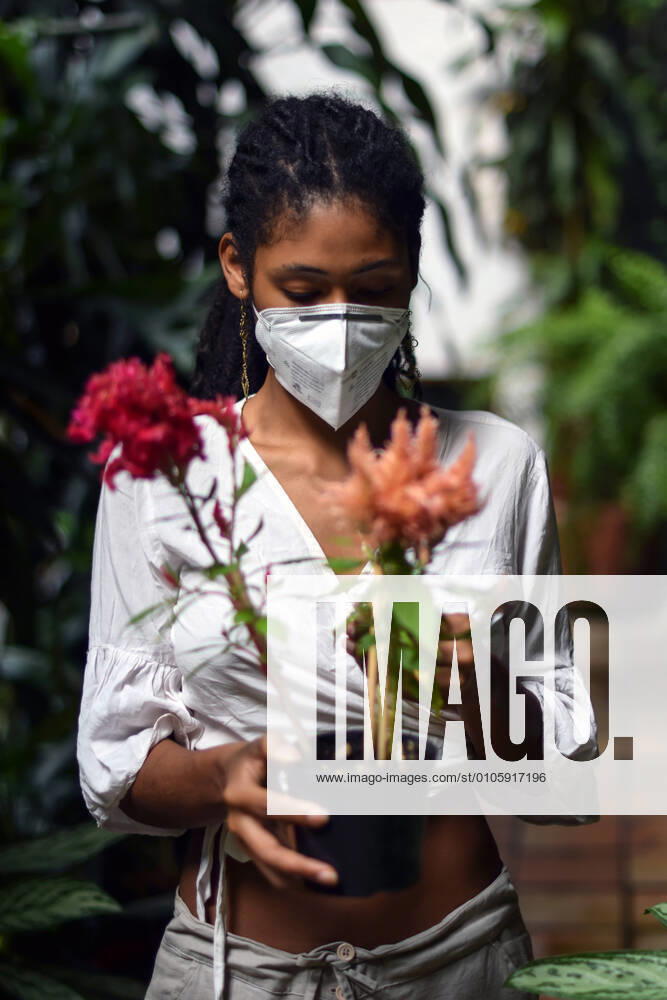 IMAGO Creative: Nächste Generation, Sozial- und klimabewusst Young woman gardening in face mask Cali Colombia
