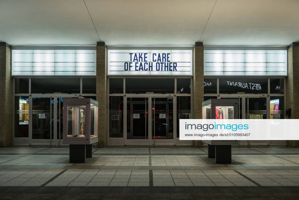 The lettering Take care of each other is on the façade of the Kino International in Berlin Mitte Photo picture enclosure Closed cinema
