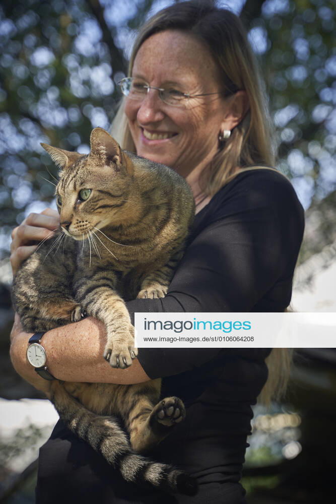 Pretty blonde woman with Bengal cat in her arms Wolfhausen, Switzerland 1082501584