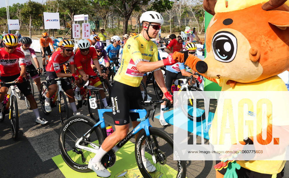 (250409) -- BAOTING, April 9, 2025 -- Norman Vahtra of China Glory-MENTECH Continental Cycling Team reacts with the mascot before Stage 3 at the 16th Tour of Hainan cycling race from Lingshui to Baoting, south China s Hainan Province, April 9, 2025. ) (SP)CHINA-HAINAN-BAOTING-CYCLING-TOUR OF HAINAN (CN) YangxGuanyu