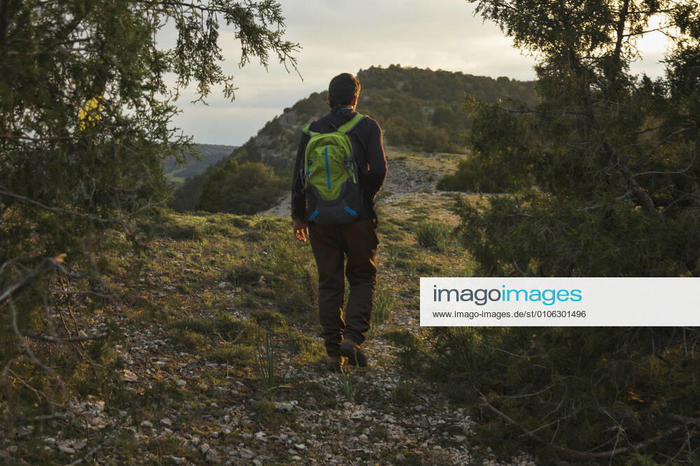 IMAGO Creative: Sommer, Abendspaziergang Man walking in the mountain surrounded by trees at sunset Spain, Castile and León, Burgos CR_MKTJQK201102D-545400-01 ,model released, Symbolfoto
