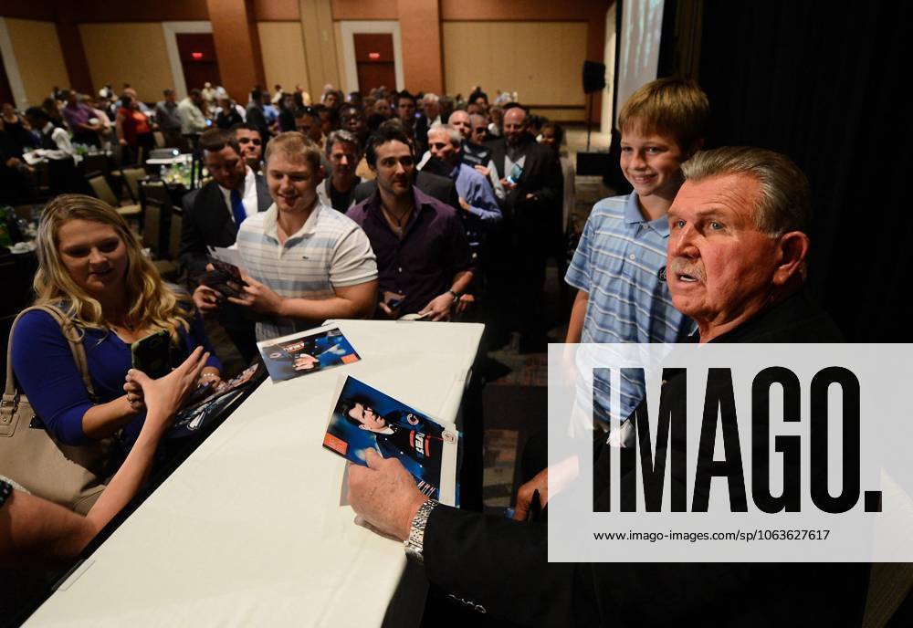 Charlotte, NC, USA - Joshua Switzer, 9, of Charlotte, N.C., gets an autograph and photo taken with former NFL, American Football Herren, USA player, coach and Hall of Fame member Mike Ditka following Ditka s address to the Charlotte Touchdown Club on Friday, May 30, 2014, in Charlotte.