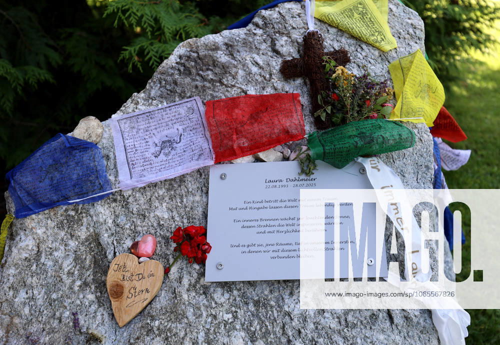 Here in the picture the memorial, temporary memorial for the former biathlete, Laura Dahlmeier from Garmisch Partenkirchen, who died in a mountaineering accident on Laila Peak, Karakorum Mountains in Pakistan, in the small spa park with a picture photo, numerous flowers and candles and a stone that looks like a mountain and is provided with Tibetan prayer flags and a saying sign, say goodbye.
